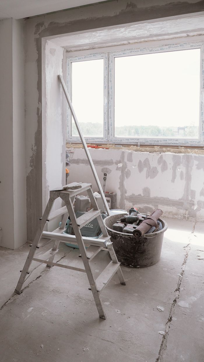 Habitación en proceso de remodelación con herramientas y escalera